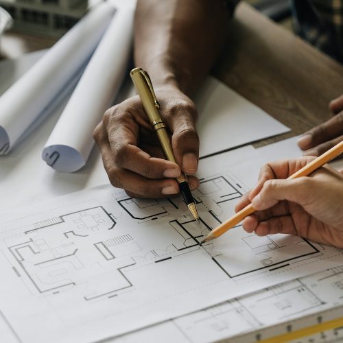 Team construction engineers working at construction site with blueprint on table